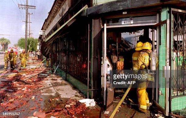 Fireman enter a shop in Los Angeles 30 Apr that had been looted and burned. Rioting broke out as a reaction to the acquittal of four police officers...