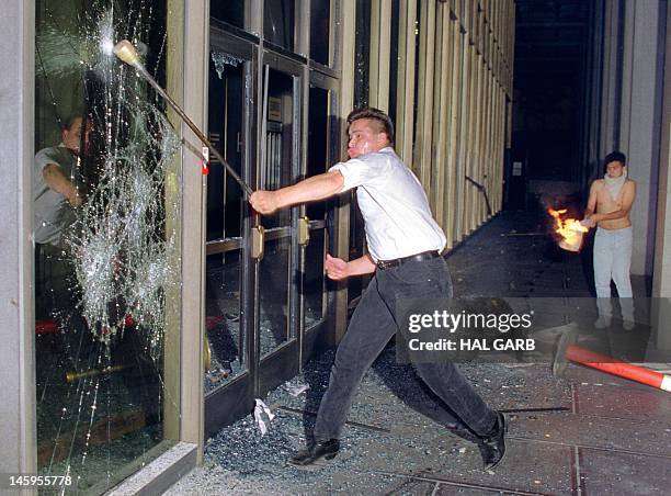 Rioter breaks a glass door of the Criminal Courts building, downtown Los Angeles, 29 April 1992, after a jury acquitted four police officers accused...