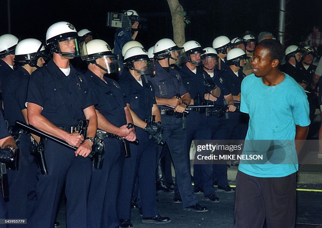4521 Police Riot A man passes in front of a line of policemen in Los Angeles, 30 April ...