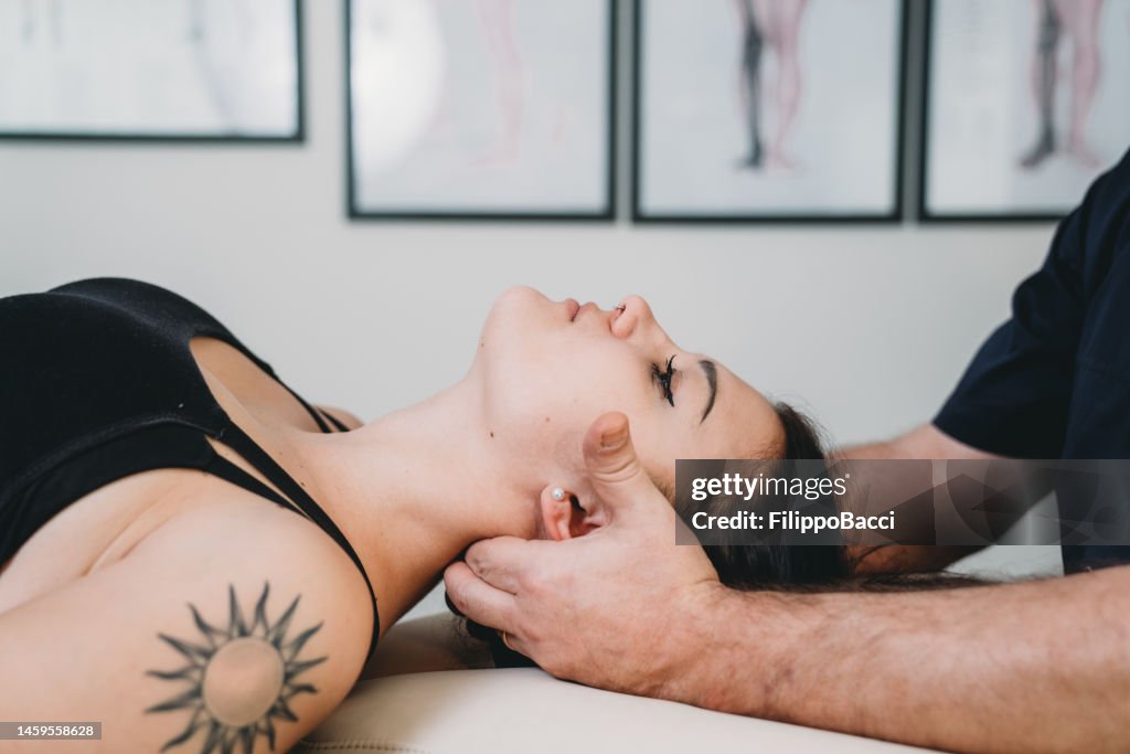 Physiotherapeut übt Chiropraktik-Techniken an einer jungen erwachsenen Patientin