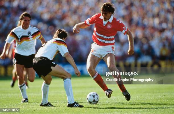 Ivan Nielsen of Denmark looks to take the ball past Mathias Herget of West Germany during the UEFA European Championships 1988 Group 1 match between...