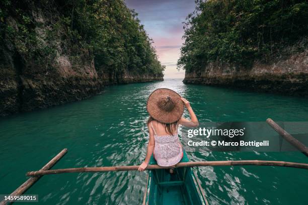 woman exploring a river on small boat at sunset, philippines - philippinische kultur stock-fotos und bilder