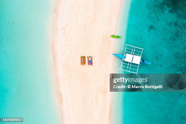 couple relaxing on sandbar among crystal waters - luzon stock-fotos und bilder