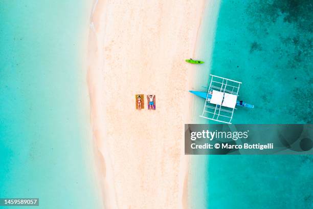 couple relaxing on sandbar among crystal waters - philippines aerial stock pictures, royalty-free photos & images