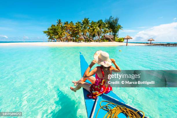 woman sitting on bangka boat approaching a tropical island - daily life in philippines stockfoto's en -beelden