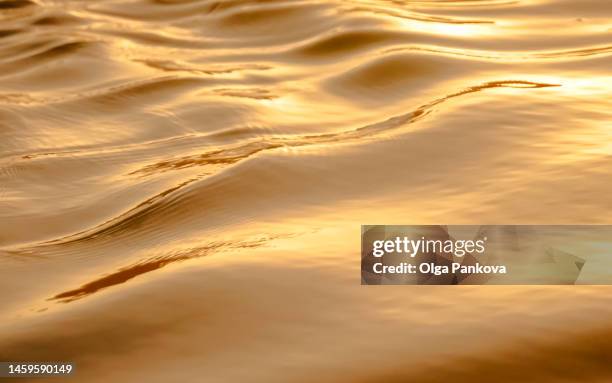 blurred texture of ocean water at sunset - gold texture stock pictures, royalty-free photos & images