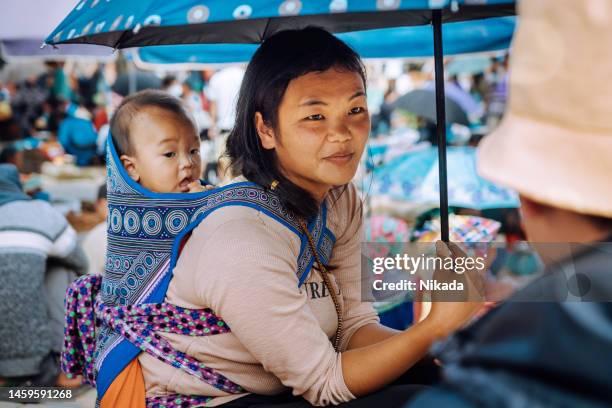 mujer vietnamita cargando un bebé en la espalda en el mercado de las tierras altas - minoría miao fotografías e imágenes de stock