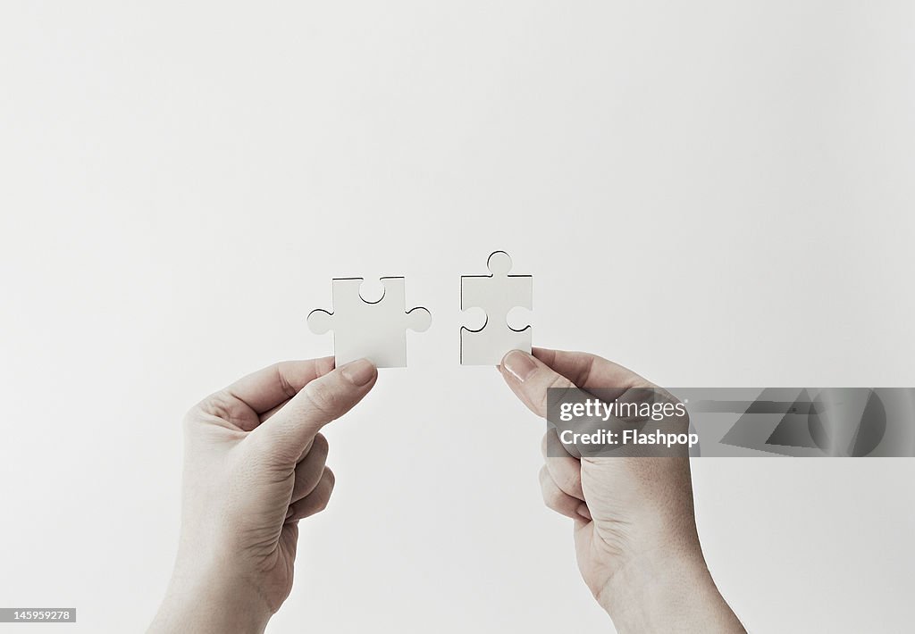 Hands holding jigsaw pieces