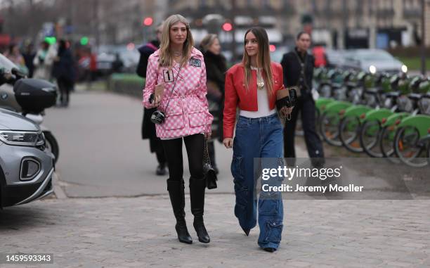Sarah Hoover wears Chanel pink checked jacket, Chanel bag and black boot, and Charlotte Groeneveld wears a red leather jacket, white top, cargo wide...