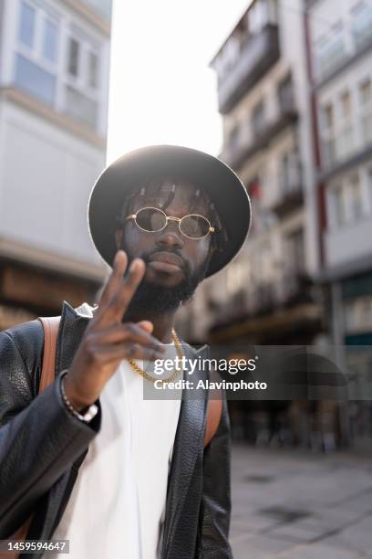 portrait of black man looking at the camera smiling  on a city street - vestimenta 個照片及圖片檔