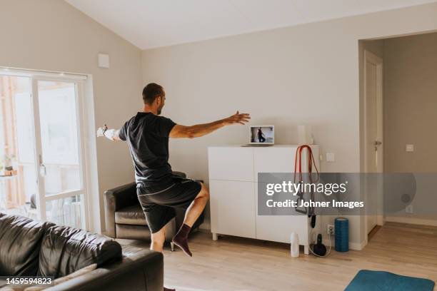 man training at home - standing on one leg stock-fotos und bilder