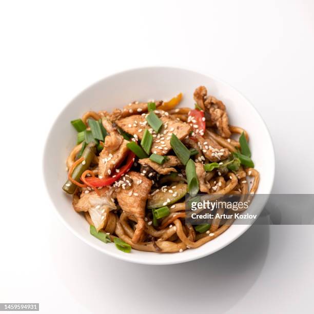 udon noodles with chicken teriyaki, vegetables and sesame seeds. asian cuisine. dish on white background. top view - udon noodle stock pictures, royalty-free photos & images
