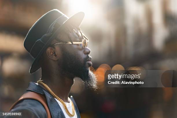 portrait of black man on a city street - vestimenta stock-fotos und bilder
