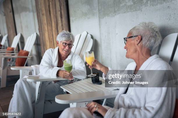 senior women relaxing in spa - bathrobe stock pictures, royalty-free photos & images