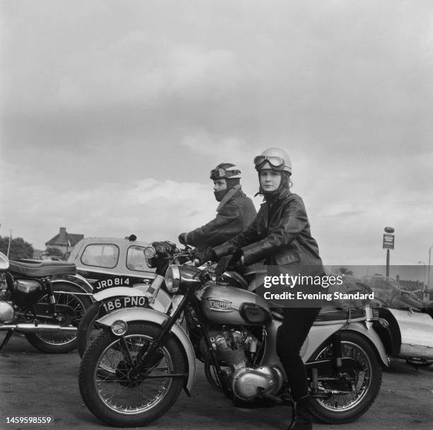 Male and a female motorcyclist sitting on their motorbikes outside a bikers' cafe, on June 14th, 1960.