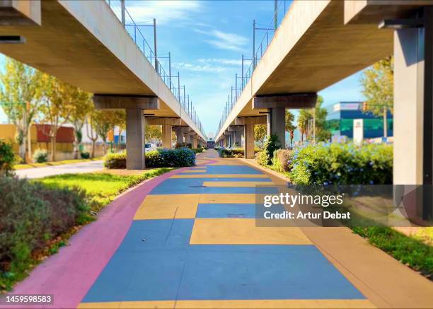 colorful promenade under the double elevated train in the barcelona city with strong diminishing perspective. - viaduct ストックフォトと画像