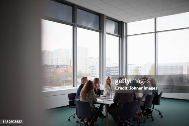 people talking during business meeting - bestuur stockfoto's en -beelden