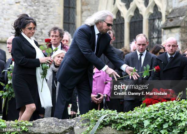 Barry Gibb places a rose on his brother's coffin watched by his wife Linda Gibb at the funeral of Robin Gibb held at St. Mary's Church, Thame on June...
