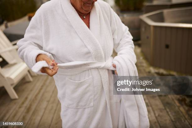 mid section of woman tying dressing gown - bathrobe stock pictures, royalty-free photos & images