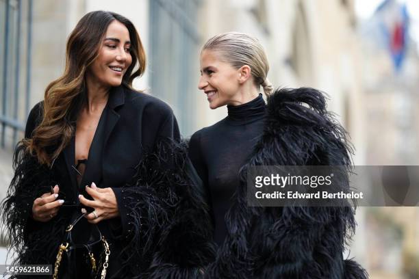 Tamara Kalinic wears black sunglasses, a black long blazer coat with embroidered feathers details from Elie Saab, diamonds and silver rings, a black...