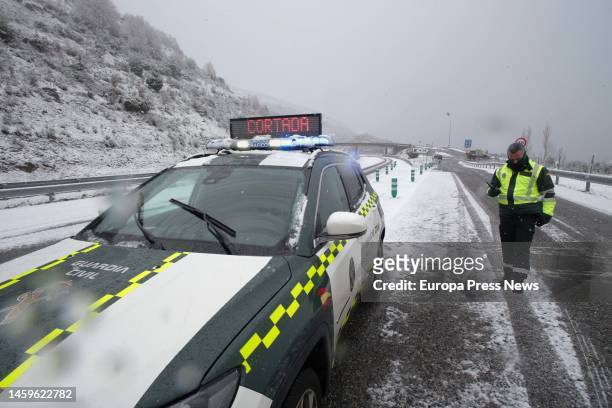 Guardia Civil car announces a road cut by snow, on 26 January, 2023 in Doncos, As Nogais, Lugo, Galicia, Spain. There is a corridor formed by the...