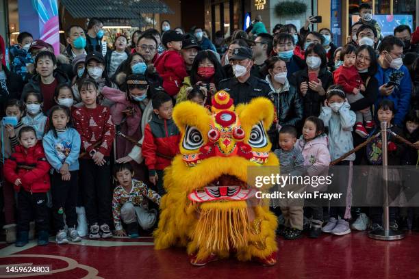 People crowd around as they watch a Lion dance during Chinese Lunar New Year and Spring Festival activities at a shopping mall on January 26, 2023 in...