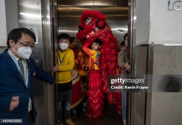 Members of a Lion dance troupe crowd in an elevator with their costumes on their way to perform during Chinese Lunar New Year and Spring Festival...