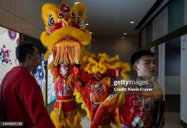 Members of a Lion dance troupe walk off an elevator with their costume on their way to perform during Chinese Lunar New Year and Spring Festival...