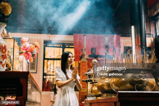 chinesische frau betet aufrichtig im chinesischen tempel - chinese temple stock-fotos und bilder