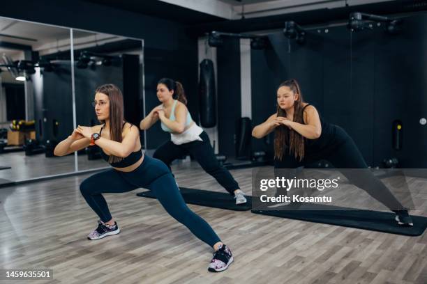 a personal trainer motivates her clients during personal training in the gym - obesity trainer stock pictures, royalty-free photos & images