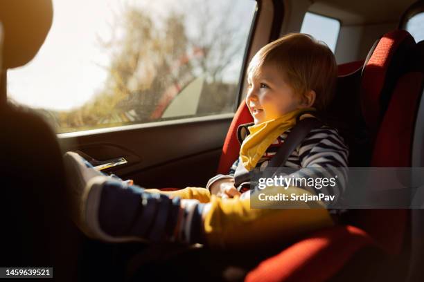 bambino di 2 anni che si siede in un seggiolino di sicurezza per bambini in macchina - toddler in car foto e immagini stock