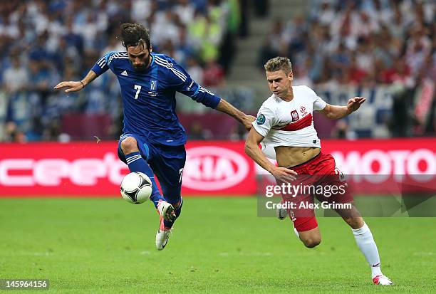 Giorgos Samaras of Greece controls the ball ahead of Lukasz Piszczek of Poland during the UEFA EURO 2012 group A match between Poland and Greece at...