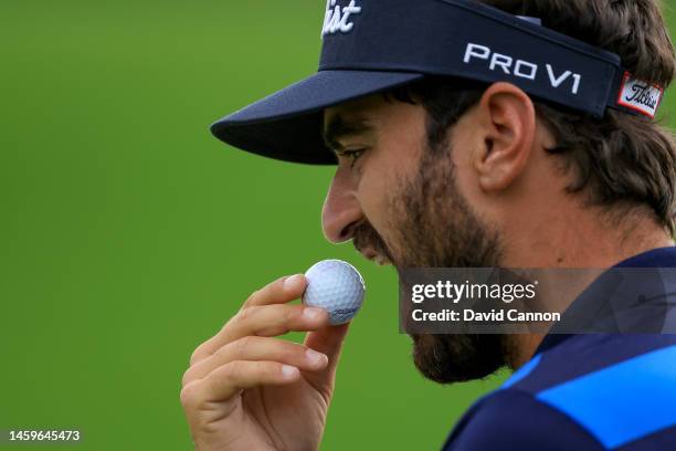 Antoine Rozner of France contemplates eating his golf ball before he plays his third shot on the 13th hole during Day One of the Hero Dubai Desert...