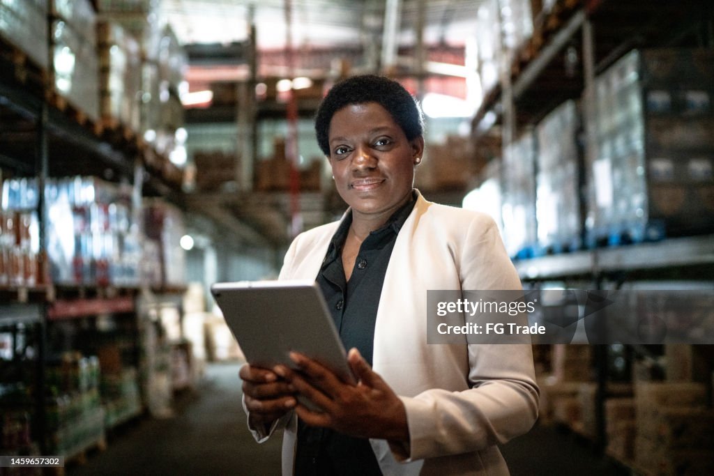 Portrait of a mature woman using the digital tablet in a warehouse