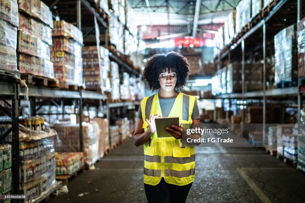 Young woman using the digital tablet in a warehouse