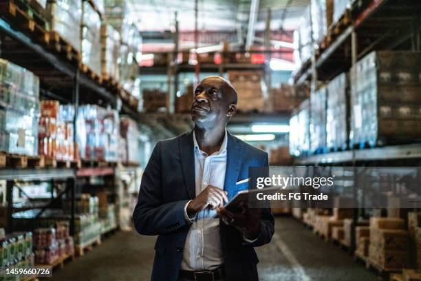 mature man using the digital tablet in a warehouse - taking inventory stock pictures, royalty-free photos & images