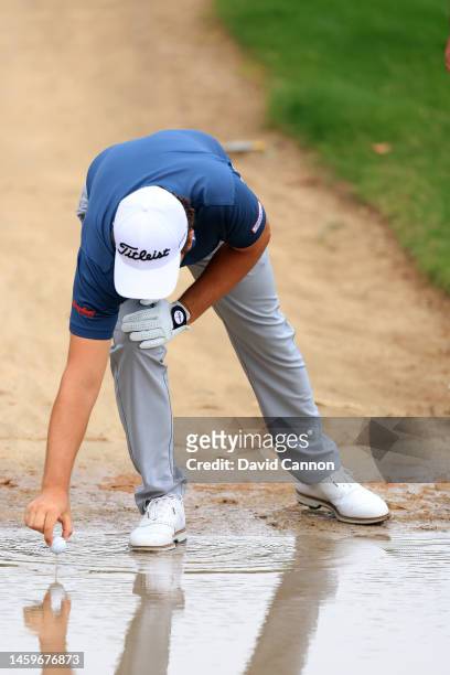 Nicolai Von Dellinghausen of Germany retrieves his golf ball from casual water from the overnight rain before he plays his second shot on the 10th...