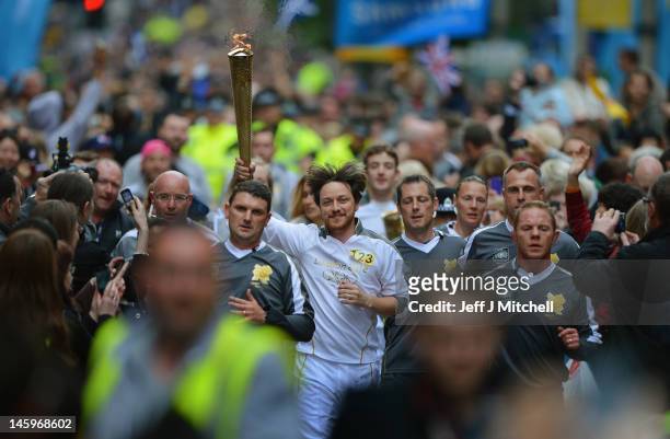 Actor James Mcavoy runs down Buchanan Street carrying the Olympic Torch during the leg between Stranrear and Glasgow on June 8, 2012 in Glasgow,...