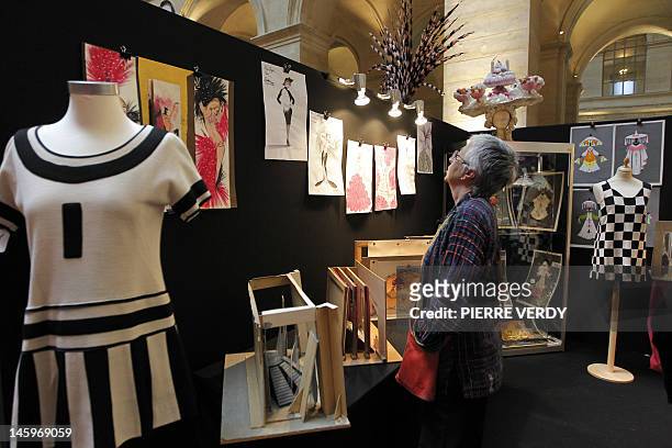 Woman looks at drawings from the Folies Bergere displayed at the Palais de la Bourse as part of the "Ventes de folie" auction in Paris on June 8,...