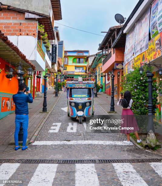 tourists taking photos at streets of the town of guatapé in colombia - guatapé stock-fotos und bilder