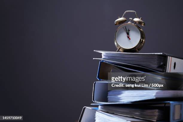 stack of document files and vintage alarm clock,malaysia - table numbers stockfoto's en -beelden