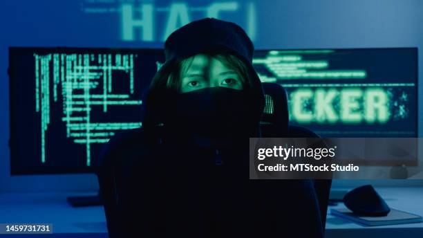 woman computer hacker breaks into government data servers and infects the system with virus in night. - anonymous mask stockfoto's en -beelden