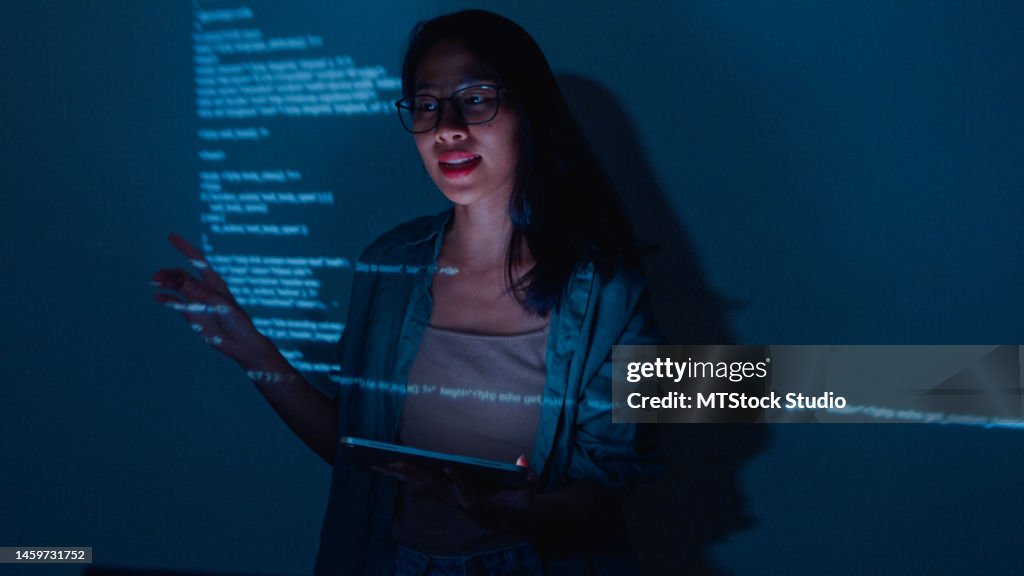 Jeune femme asiatique développeurs de logiciels mentor leader manager parlant à l’équipe de direction analysant le code source au bureau la nuit.