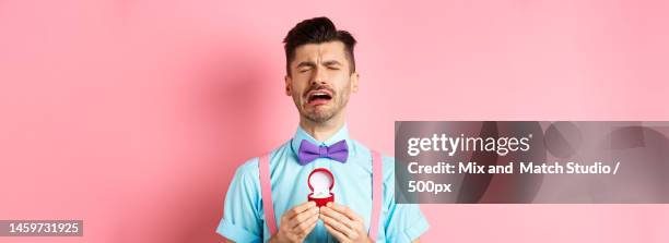 valentines day heartbroken guy crying and holding engagement ring - man proposing indoor stock pictures, royalty-free photos & images