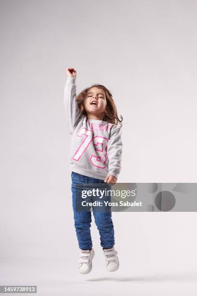 girl screaming and jumping with one arm raised - sweatshirt fotografías e imágenes de stock