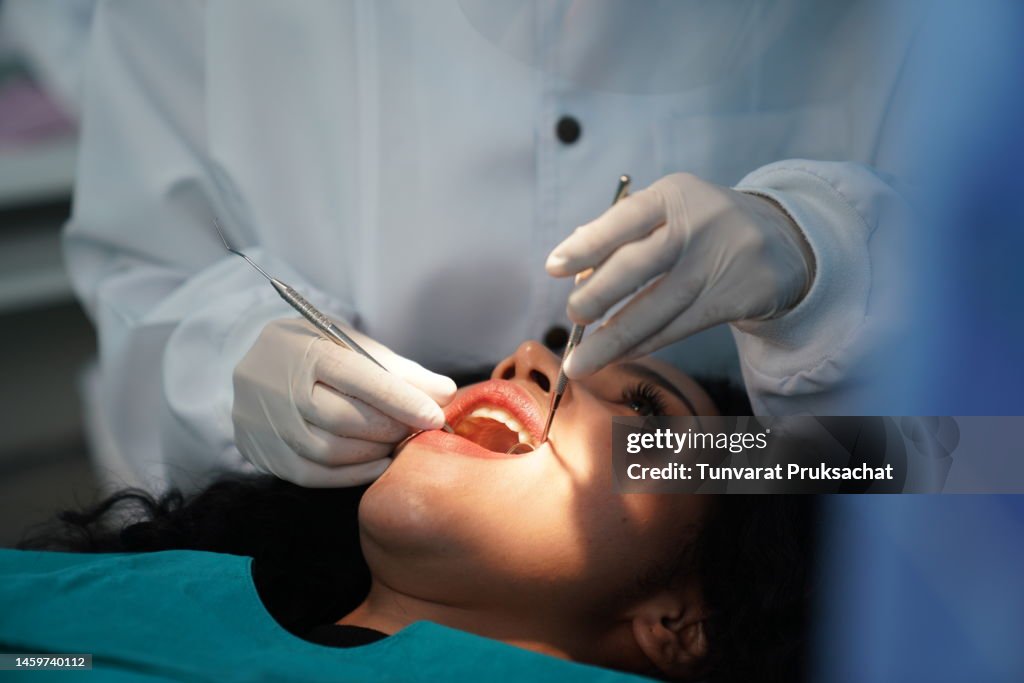 Dentist checking patient's teeth .