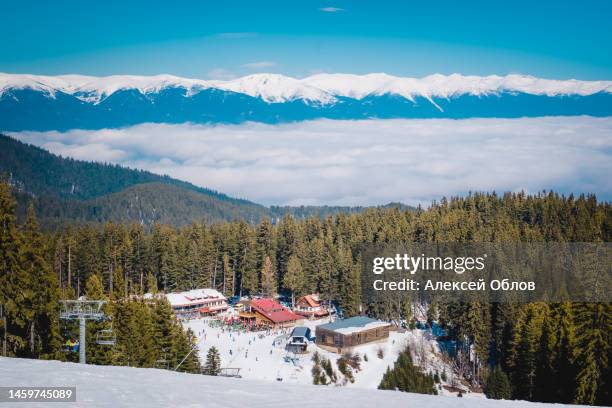 winter landscape with panorama of bansko above the clouds. famous ski resort in bulgaria. view of the ski slopes and the pirin mountains - bansko - fotografias e filmes do acervo