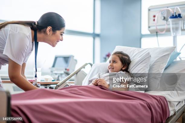 nurse checking on a young patient - nurse maroon stock pictures, royalty-free photos & images