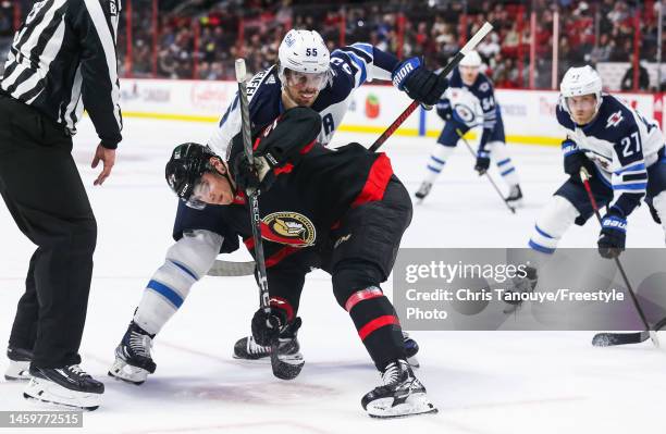 Mark Scheifele of the Winnipeg Jets battles with Shane Pinto of the Ottawa Senators after a face-off during the game at Canadian Tire Centre on...