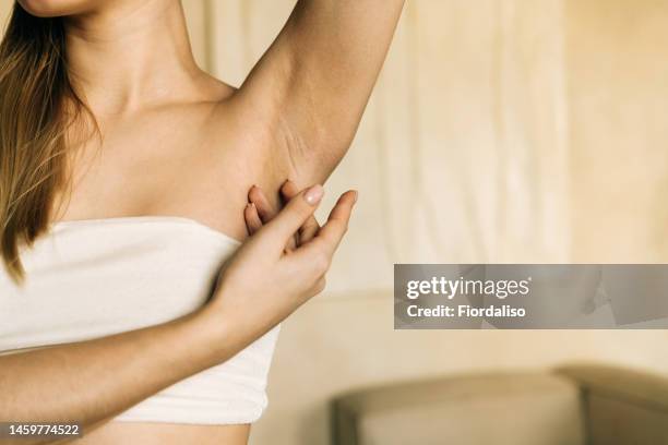 woman holding bottle of spray, thermal water, moisturizing liquid, hydrolat, body lotion - armpit stock-fotos und bilder